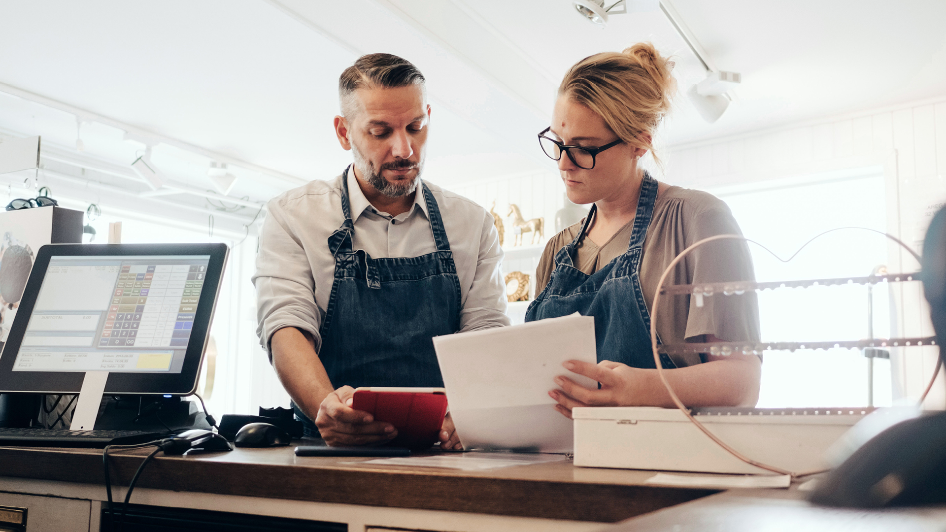 img-full-serious-owners-discussing-over-financial-receipt-at-checkout-counter-in-store-1920×1080